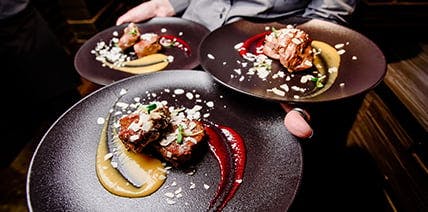 2 Personen in Liegestühlen am Pool bei Sonnenuntergang